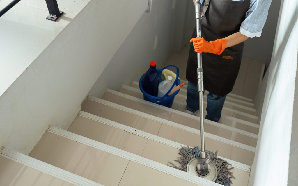 Asian cleaning service housekeeper women swipe floor in office.